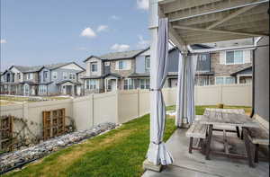 View of backyard with a residential view, outdoor covered dining area, a fully fenced backyard, automatic sprinklers, a lower terraced area perfect for a small garden and sliding doors with patio access