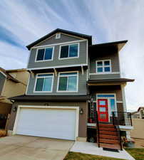 View of front of property featuring fully fenced yard, an attached garage, and concrete driveway