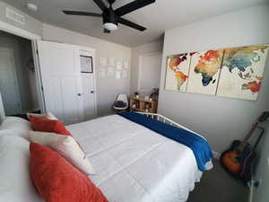 Bedroom #2 featuring large window with custom fit vinyl blinds, cut and loop carpet, ceiling fan with light, ample closet space and wide baseboards