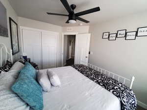 Bedroom #3 featuring large window with custom fit vinyl blinds, cut and loop carpet, ceiling fan with light, ample closet space and wide baseboards