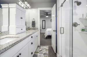 Full primary ensuite featuring a subway tile stamped insert double vanity with undermount sinks, wide baseboards and vinyl flooring
