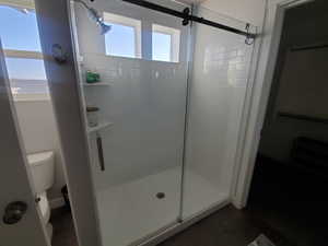 Full primary ensuite featuring a subway tile stamped insert double vanity with undermount sinks, wide baseboards and vinyl flooring