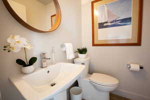 Bathroom featuring baseboards, a sink, and toilet