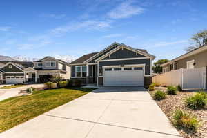 Craftsman house with a garage, a front lawn, fence, board and batten siding, and concrete driveway