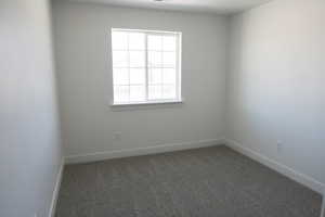 Unfurnished room with baseboards and carpet