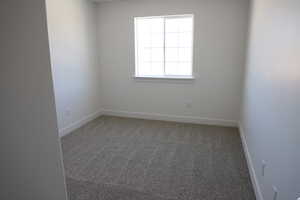 Empty room featuring carpet floors and baseboards