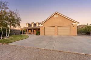View of front of house with a garage, fence, a front yard, a porch, and driveway
