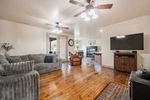 Living room with ceiling fan, wood-type flooring, and visible vents