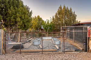 View of yard with fence, exterior structure, and a vegetable garden