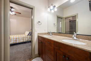 Bathroom with double vanity, a sink, ceiling fan, and ensuite bath