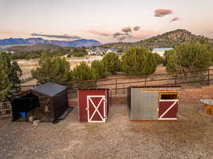 View of outbuilding featuring an outdoor structure, a mountain view, and fence