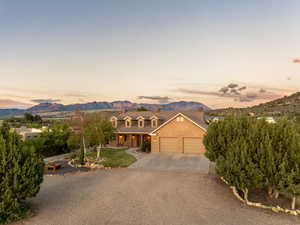 View of front of property featuring covered porch, driveway, a chimney, a mountain view, and an attached garage
