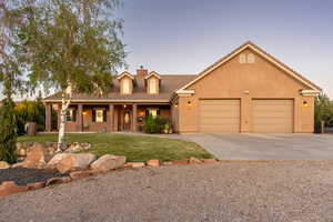 View of front of property with a front lawn, a garage, a chimney, concrete driveway, and covered porch