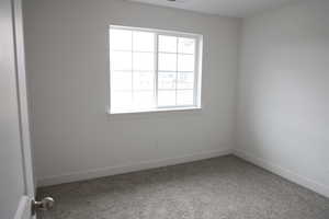 Empty room with carpet floors, baseboards, and visible vents