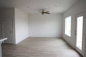 Unfurnished room with ceiling fan, baseboards, and light wood-style floors