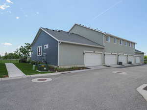 View of home's exterior with stucco siding, a lawn, and fence