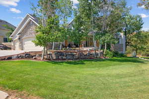 Front of home featuring stone and stucco with private walkway and large beamed covered porch (some trees have since been removed).