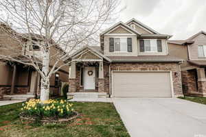 Craftsman-style home with an attached garage, a shingled roof, stucco siding, and concrete driveway