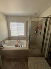 Bathroom featuring a shower stall and a bath