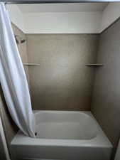 Bathroom with a shower with curtain and a tub to relax in
