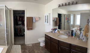 Full bathroom with visible vents, a walk in closet, and a stall shower