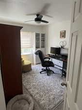Office area with carpet flooring and a ceiling fan