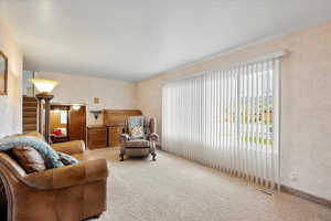 Living area featuring visible vents, carpet, a wealth of natural light, and stairway