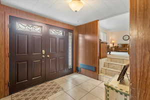Entryway featuring wood walls and light tile patterned floors