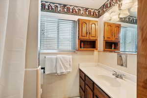 Bathroom featuring vanity, a wainscoted wall, and tile walls