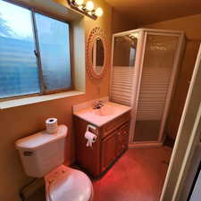 Full bathroom with vanity, a stall shower, and toilet