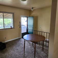Dining room featuring carpet floors, baseboards, and a textured ceiling