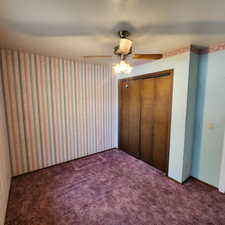 Unfurnished bedroom featuring a closet, a ceiling fan, and carpet