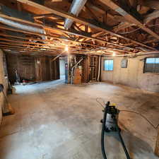 Below grade area featuring heating unit and electric panel