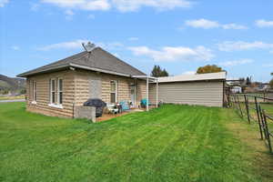 Back of house with a patio area, fence, a yard, and roof with shingles