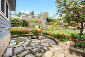View of patio with an outdoor fire pit and fence