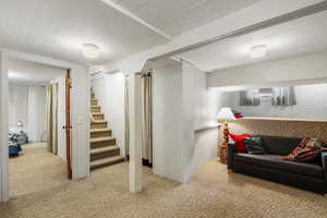 Finished basement with carpet flooring and stairs