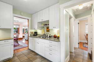 Kitchen with a sink, open shelves, dishwasher, and tile patterned floors