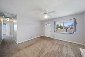 Unfurnished room with visible vents, carpet flooring, baseboards, and a ceiling fan