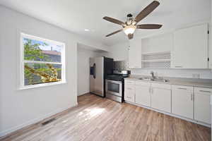 Kitchen with a ceiling fan, visible vents, appliances with stainless steel finishes, open shelves, and a sink