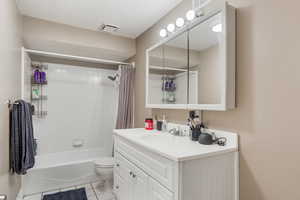 Bathroom with shower / bath combo, tile patterned flooring, vanity, toilet, and visible vents