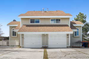 Traditional-style house with an attached garage, fence, driveway, and a chimney