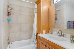 Full bathroom with shower / bath combo with shower curtain and vanity