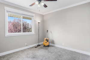 Carpeted empty room featuring crown molding, a ceiling fan, baseboards, and visible vents