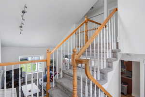 Staircase featuring track lighting and carpet flooring