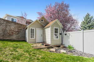 View of outbuilding with fence