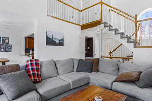 Living area featuring a towering ceiling and stairway