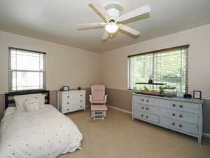 Bedroom with baseboards, ceiling fan, and carpet flooring