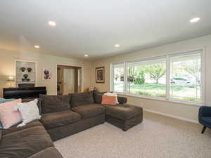 Carpeted living room featuring recessed lighting and baseboards