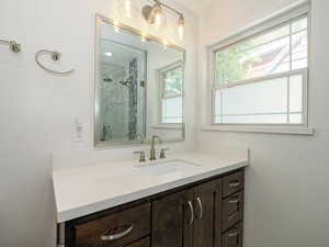 Bathroom with a marble finish shower and vanity