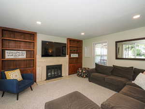 Living room featuring recessed lighting, carpet flooring, and a high end fireplace